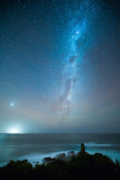 人在繁星闪烁的夜晚,站在海滩上
